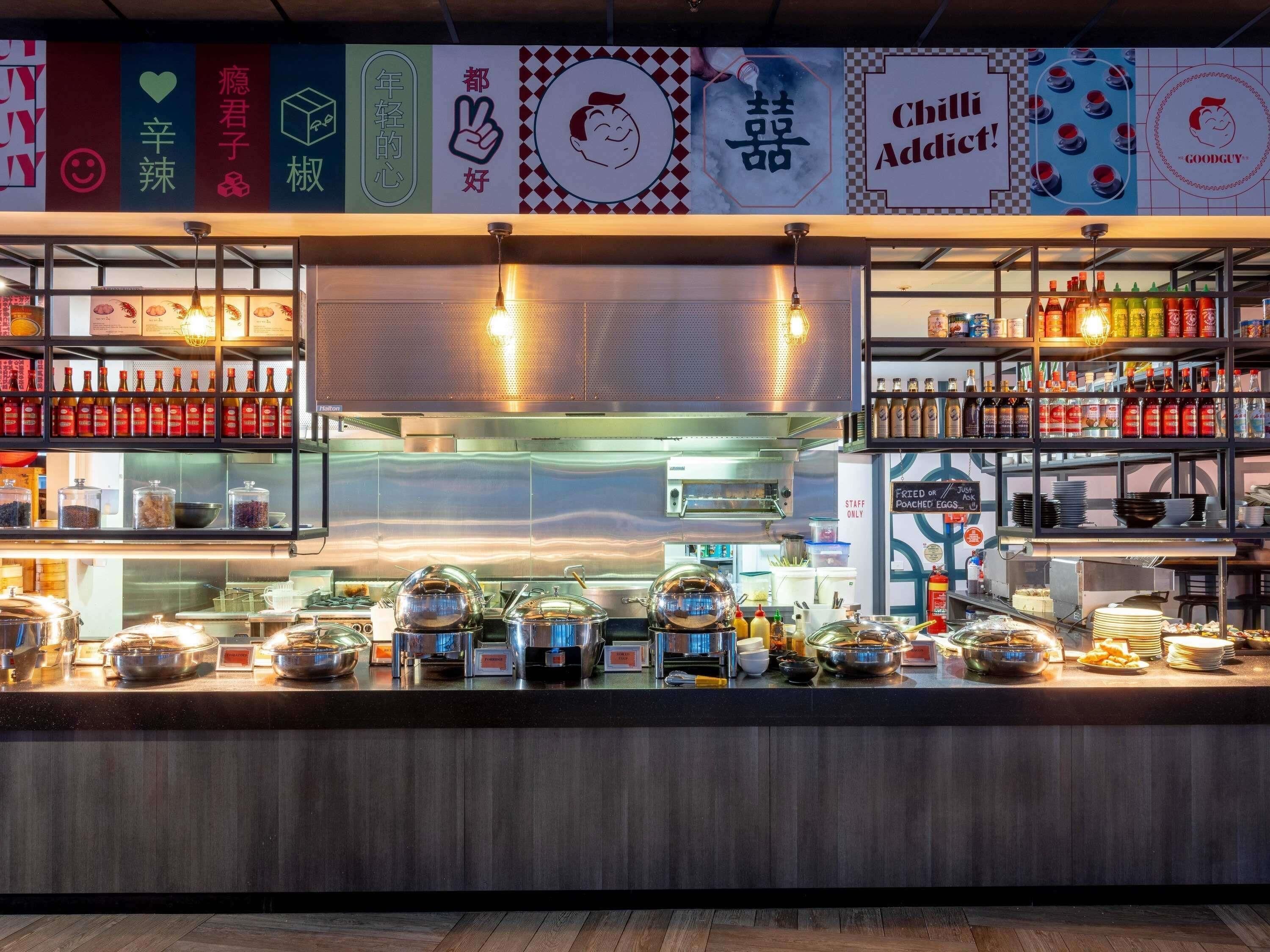 Un buffet avec différents plats présentés dans des récipients et accompagné de condiments variés.