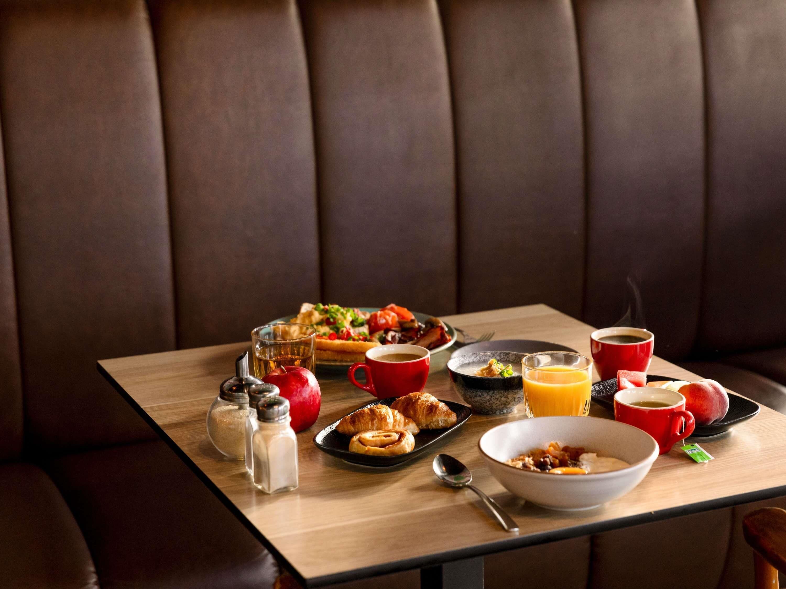 Een ontbijttafel met verschillende soorten eten en toevoegingen.