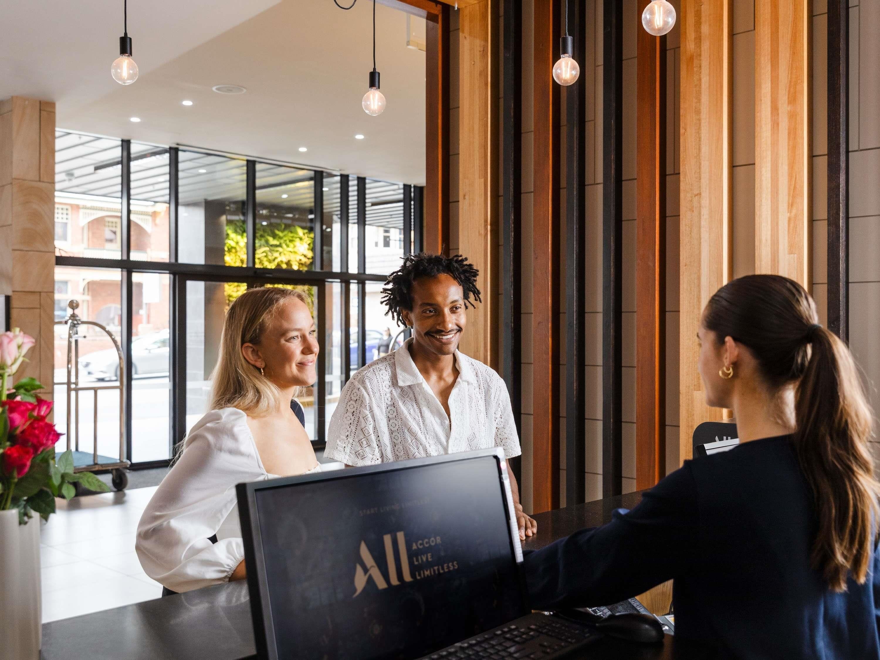 A reception desk with a laptop displaying "All Live Limitless".