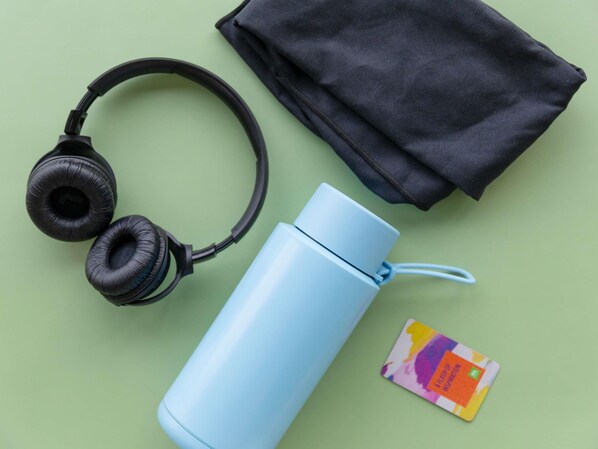 Headphones, a water bottle, and a black pouch on a green surface. - ibis Styles Hobart (Hobart)
