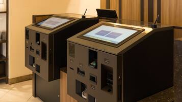 Zwei Selbstbedienungskioske mit Touchscreens, einem Stifthalter und einem kleinen Bildschirm.