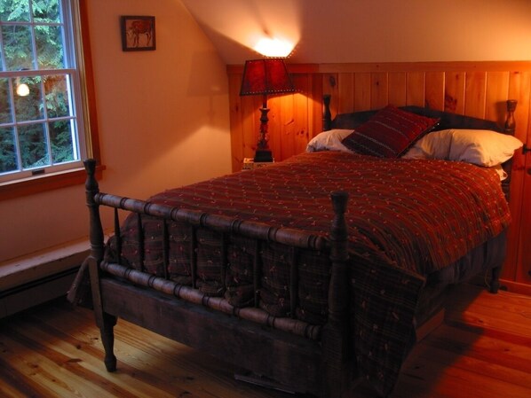 A wooden bed with a red patterned bedspread, a wooden headboard, and a nightstand with a lamp. - Pet Friendly Cabin Doh-Ray up @ 1500 ft (Shady)