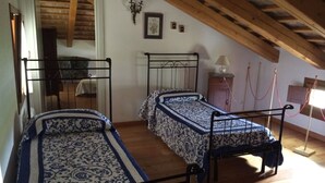 A room with two bunk beds, wooden flooring, a wooden ceiling, a small bedside table with a lamp, and a wall-mounted picture. - Magnolia, charming residence in the Barchessa of Venetian Villa: Villa Pastori (Mira)