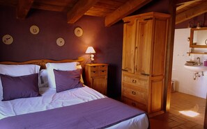 A bedroom with a bed, wooden wardrobe, bedside table with lamp, and a bathroom with sink and mirror. - Beautiful Rural House, private pool, 7 rooms all with bathroom, 14-17 p (Cardona)