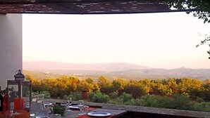 An outdoor dining area with a table set for four, overlooking a mountainous landscape. - Villa with pool between Florence and Arezzo. Magical view  (Loro Ciuffenna (Province of Arezzo))