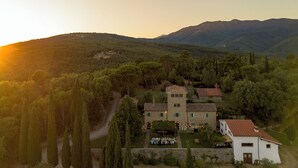 A stone building with a tower, surrounded by trees and hills. - Villa with pool between Florence and Arezzo. Magical view  (Loro Ciuffenna (Province of Arezzo))