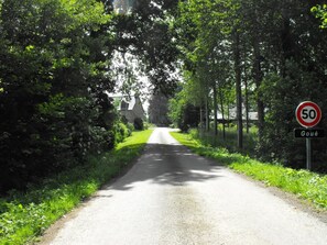 Une route de campagne avec un panneau indiquant la limitation de vitesse à 50 km/h.
