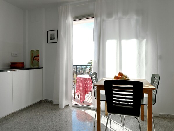 Ett kök med ett matbord, stolar och utsikt över omgivningen.