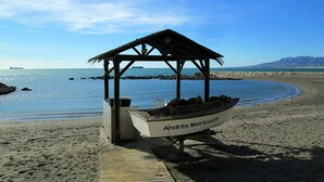 A beach with a wooden structure labeled "Andres Maricuch" and a boat on display. - Apart. 3, Casa Malaga with sea views & balcony (Málaga)