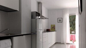A modern kitchen with a built-in oven, microwave, and a stainless steel range hood. - Apart. 3, Casa Malaga with sea views & balcony (Málaga)