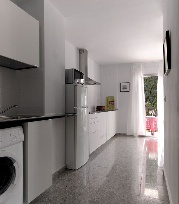 A modern kitchen with a built-in oven, microwave, and a stainless steel range hood. - Apart. 3, Casa Malaga with sea views & balcony (Málaga)