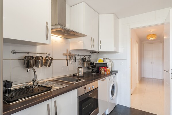 A modern kitchen with stainless steel appliances, a built-in oven, and a dishwasher. - Blue Fin, your unfogettable getaway in Tarifa! ☀️ (Tarifa)