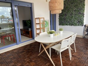 A modern dining area with a white table, white chairs, and a woven pendant light. - Blue Fin, your unfogettable getaway in Tarifa! ☀️ (Tarifa)