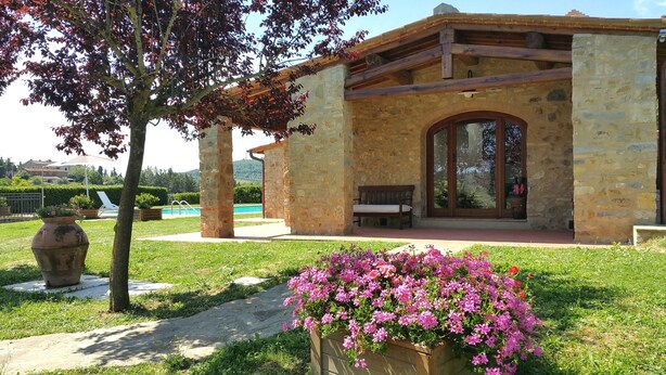 A stone building with a wooden bench and a glass door. - Stone house with private exclusive infinity pool in Chianti (San Filippo A Ponzano)