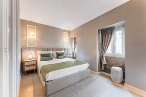 A bedroom with a large bed, bedside tables, a window with curtains, and a nightstand. - Victoria Project - House I - Private Parking (Porto)