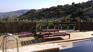 A pool area with wooden deck, lounge chairs, and a view of hills. - El Mirador Rocabella Private Pool Apartment (Alora)