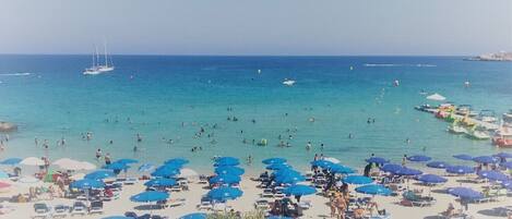 Una playa cerca, sillas reclinables de playa, toallas de playa