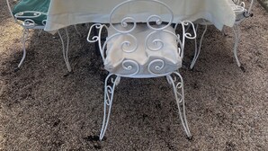 A long outdoor dining table set with white metal chairs, a white tablecloth, and colorful glassware. - Apartment in Farmhouse (Montepulciano)