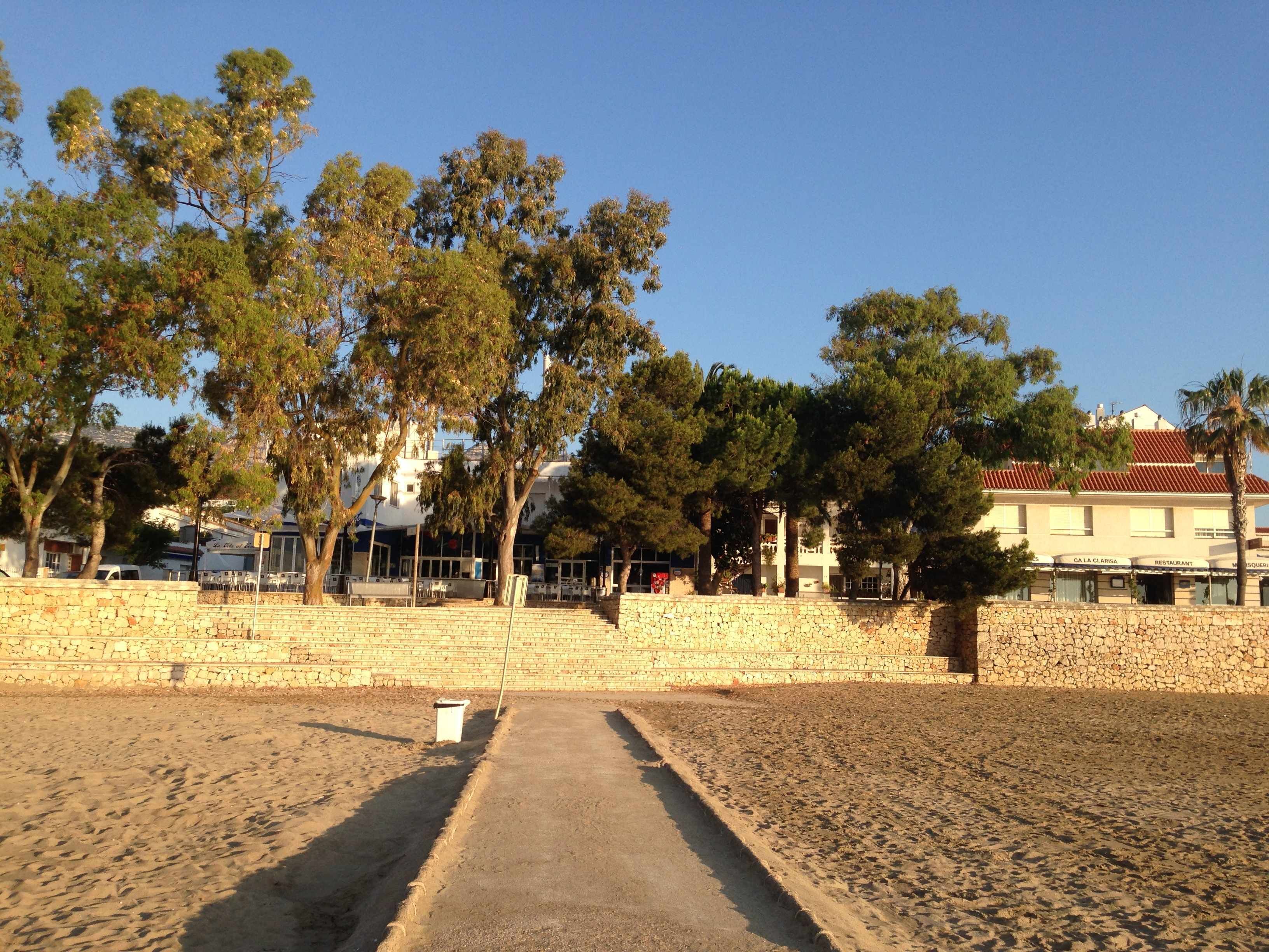 Un sendero pavimentado que conduce a un muro de piedra, con un restaurante llamado 'CA LA CLARISA' a la derecha.