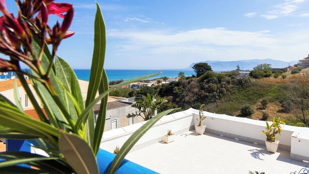A rooftop terrace with potted plants, a clear view of the sea, and distant hills. - Bright apartment with sea view 200 meters from the beach wi fi car rental (balestrate)