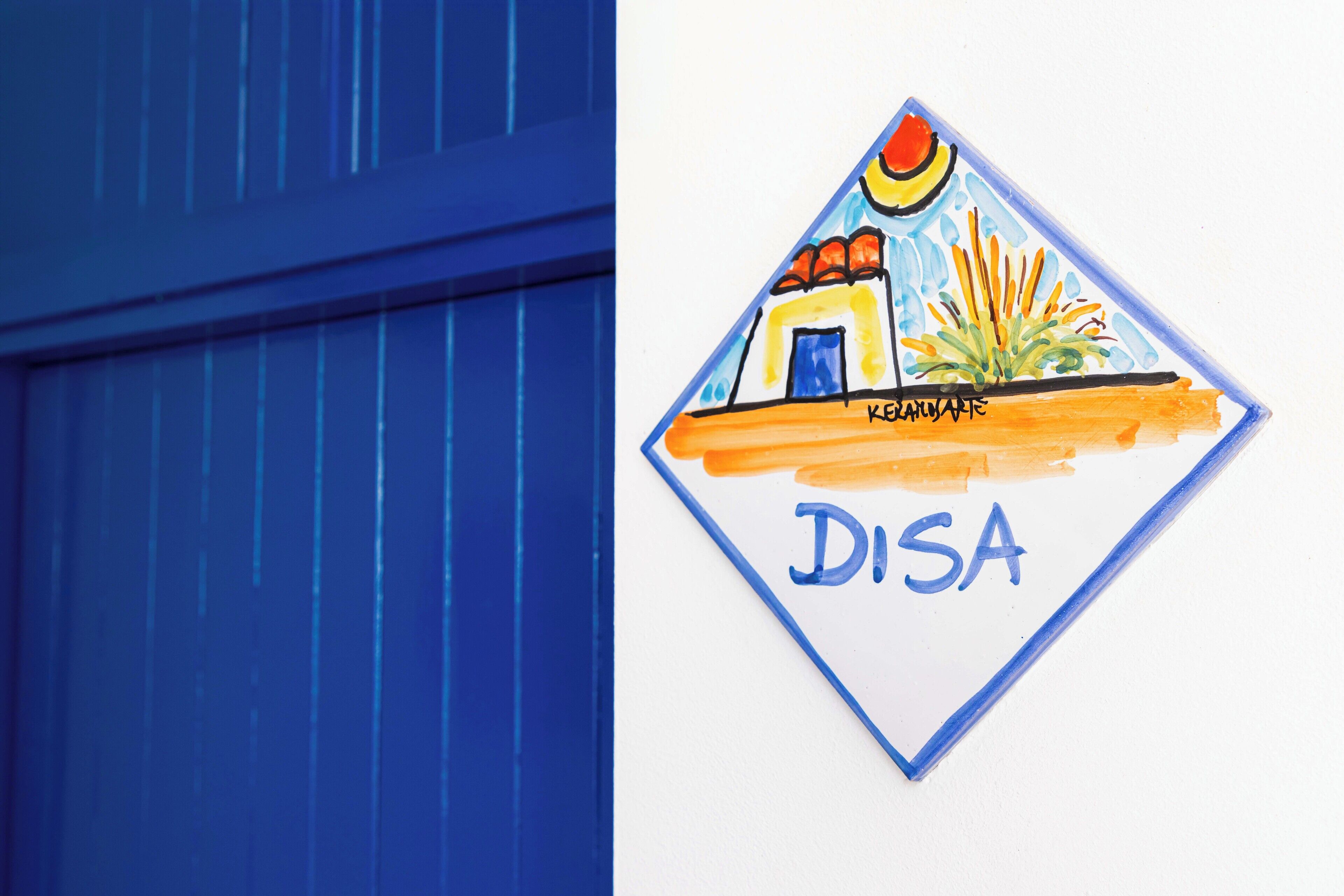 A sign with a colorful illustration of a building and the word "DISA" on a white background.
