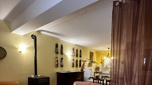 Una sala de estar con un sofá, una mesita, una chimenea y una cortina.