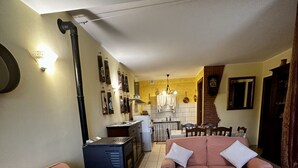 Una sala de estar con dos sofás, una mesa de comedor y una cocina al fondo.
