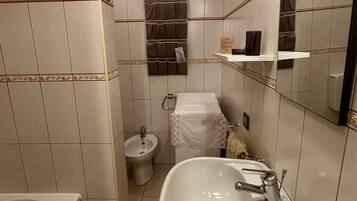 Bathtub, hair dryer, towels, toilet paper
