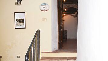 Un escalier avec une rampe, un tableau encadré au mur et une enseigne au-dessus de la porte.