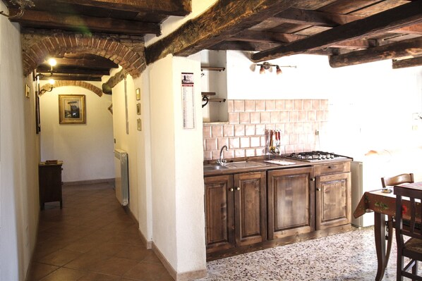 A kitchen with wooden cabinets, a tiled backsplash, and a gas stove.