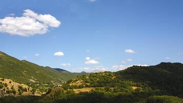 A mountainous landscape with a clear sky and scattered clouds.