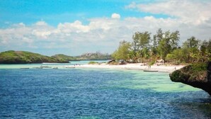 A coastal landscape with clear blue waters, a sandy beach, and a small island in the distance. - Superior villa with garden / pool and personal service to 150mt sea (WATAMU)