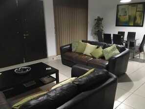 Relax in this stylish living room with a sofa, coffee table, and dining area.