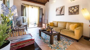 A living room with a sofa, a coffee table, a chessboard, and a television.