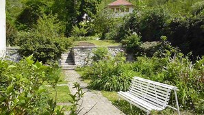 A garden pathway leading to a white bench, surrounded by lush greenery and a stone wall. - Apartment/ flat - AX LES THERMES (Ax-Les-Thermes)