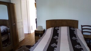 A bedroom with a bed, a wooden nightstand, a chair, and a wardrobe. - Apartment/ flat - AX LES THERMES (Ax-Les-Thermes)