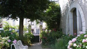 A paved garden path leading to a building with a stone facade and an arched entrance. - Apartment/ flat - AX LES THERMES (Ax-Les-Thermes)