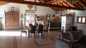 Amplia sala de estar con comedor, muebles de madera y una chimenea acogedora.