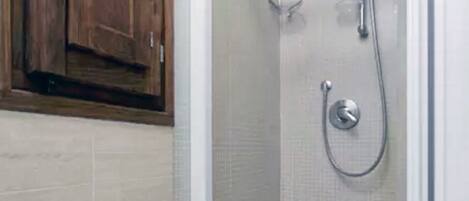 Une salle de bain équipée de toilettes, d’une douche et de meubles en bois.