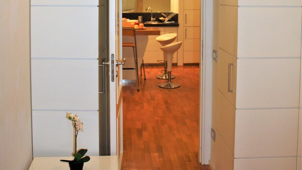 A narrow hallway with a white table and a potted plant. - NAVONA SECRET SUITE (Roma)