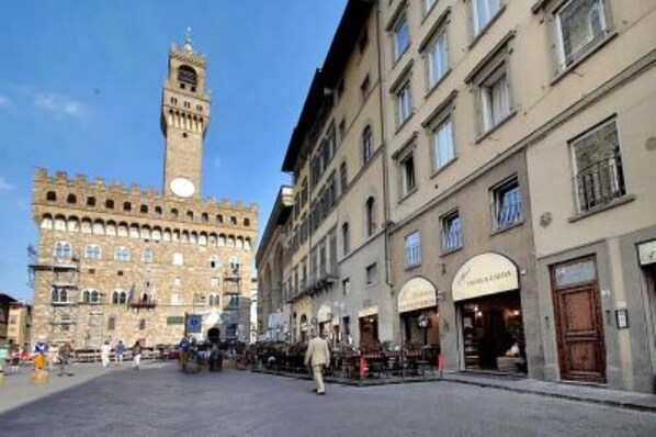 A historic square with a prominent tower, traditional buildings, and outdoor seating areas. - Studio in Piazza Signoria - Internet WiFi, Air Conditioning New 2011 (Firenze)
