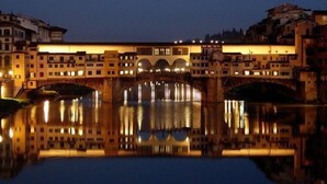 A historic building with a reflective water body in front, featuring a bridge and multiple arches. - Studio in Piazza Signoria - Internet WiFi, Air Conditioning New 2011 (Firenze)