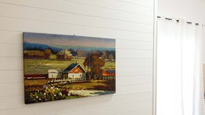 Una pintura de un paisaje rural sobre un panel blanco.