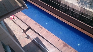 Ein Schwimmbecken mit Holzdeck und Metallzaun.