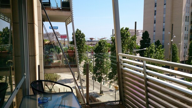 Ein Balkon mit Blick auf eine Stadtlandschaft, darunter ein Gebäude mit der Aufschrift 'DEATHLON'.