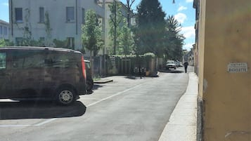 A street with parked cars, buildings, and a sign indicating a bicycle entrance.