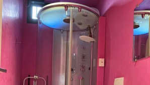 Un bagno con doccia vetrata, un water e un lavandino.