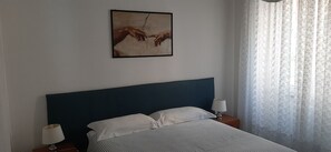 Une chambre à coucher avec un lit, deux tables de chevet, une lampe sur chaque table et un tableau au mur.