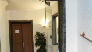 A staircase leading to a room with a wooden door and a potted plant.