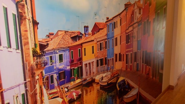 A narrow waterway with colorful buildings on either side. Boats are docked along the waterway. - LOVE NEST IN CUENCA (Arcas)